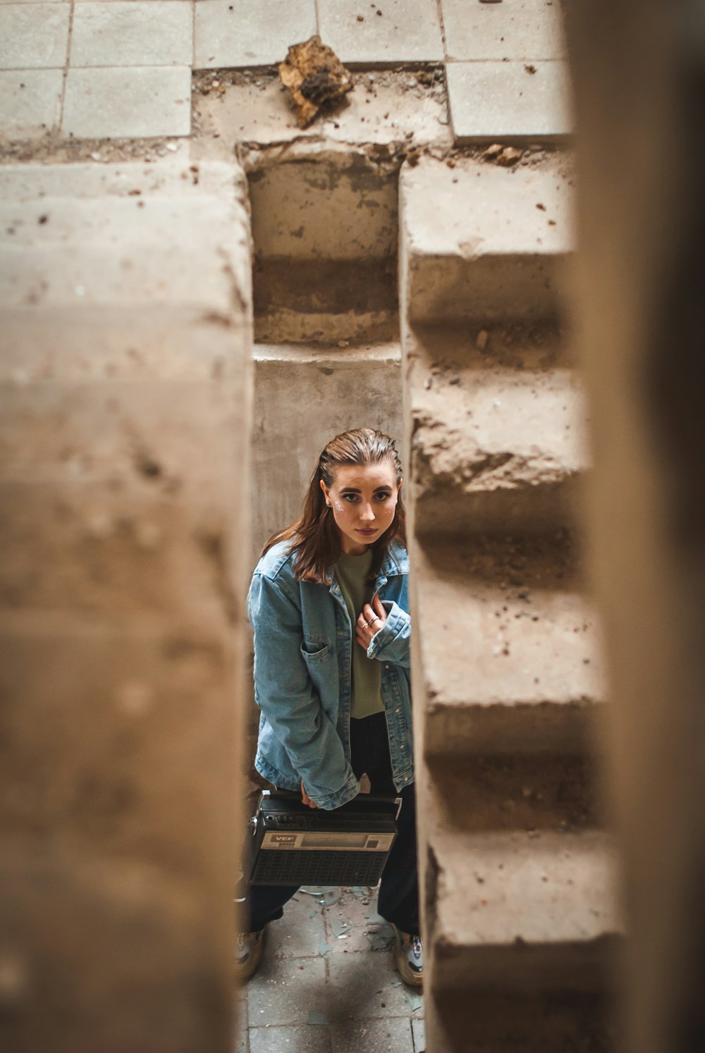 woman in blue denim jacket standing on stairs