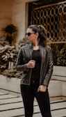 woman in black leather jacket wearing black sunglasses