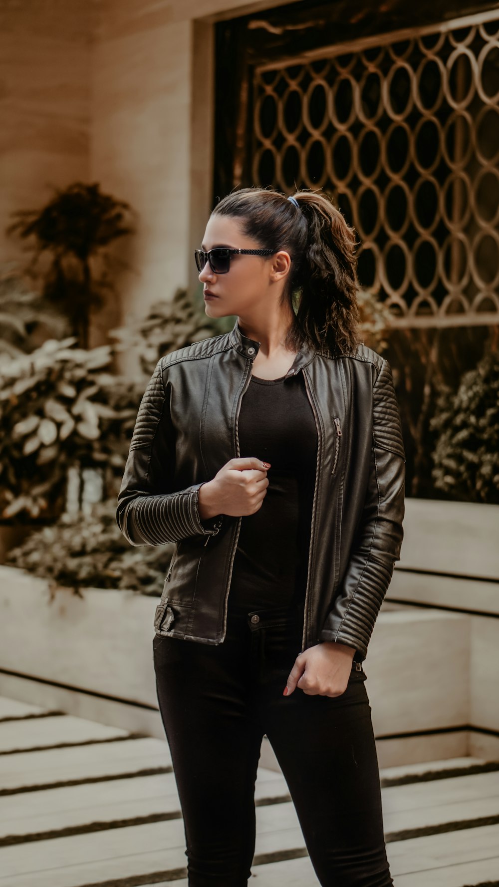 Frau in schwarzer Lederjacke mit schwarzer Sonnenbrille