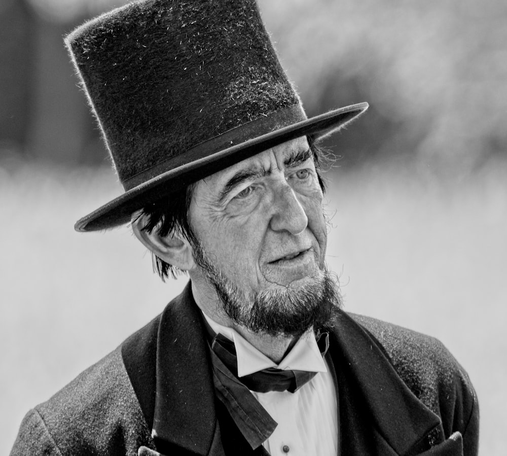 man in black hat and brown coat