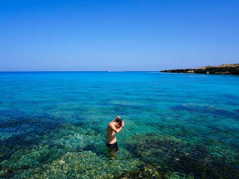 woman in blue bikini on body of water during daytime