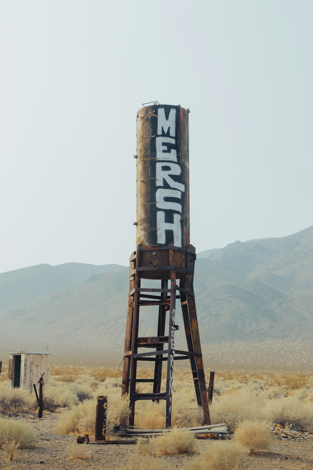 brown metal water tank on brown field during daytime