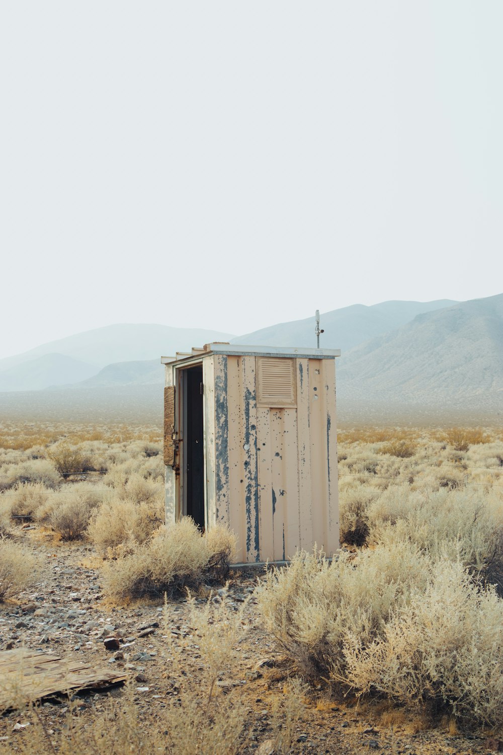 brown wooden house on brown grass field during daytime