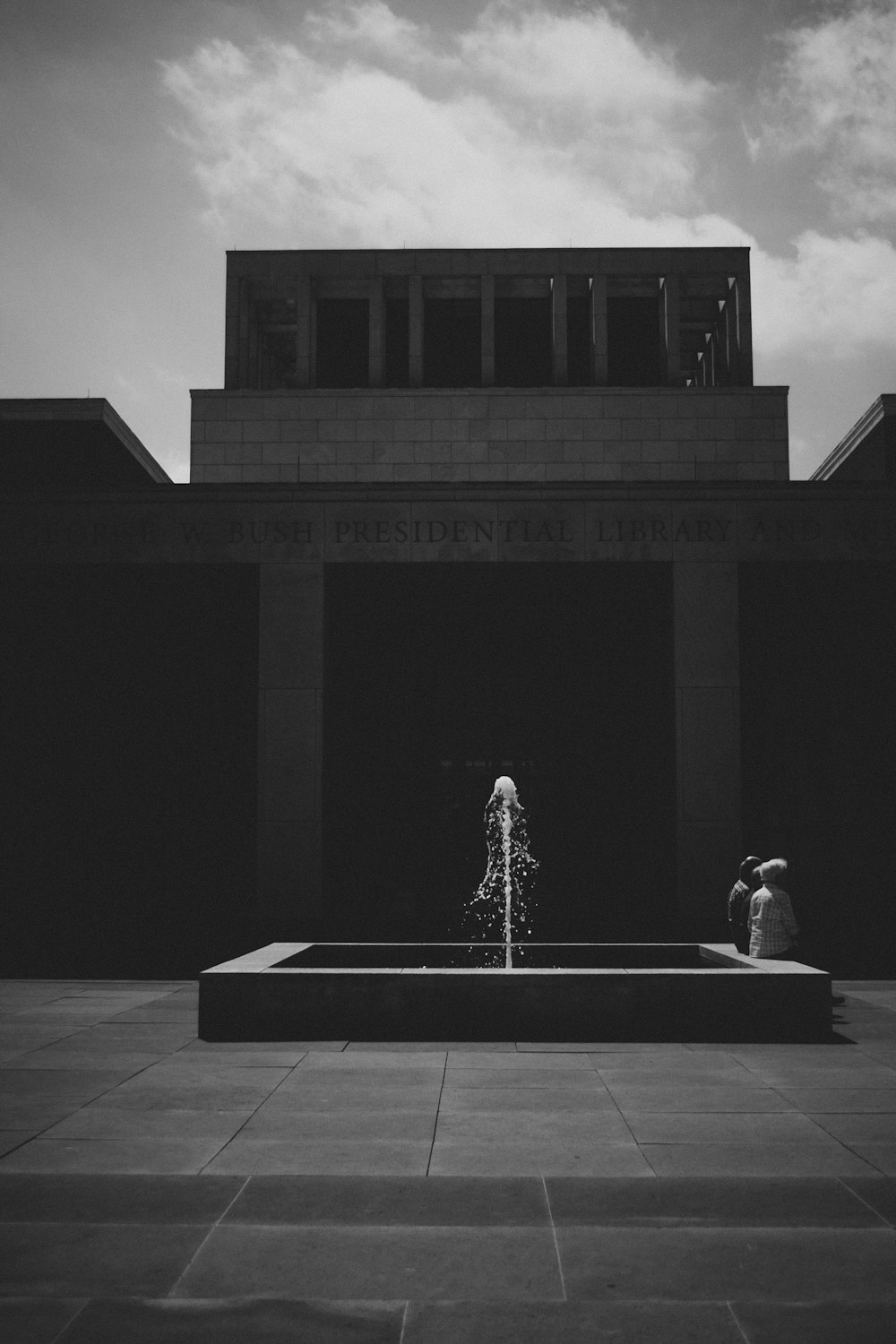 grayscale photo of people in front of building