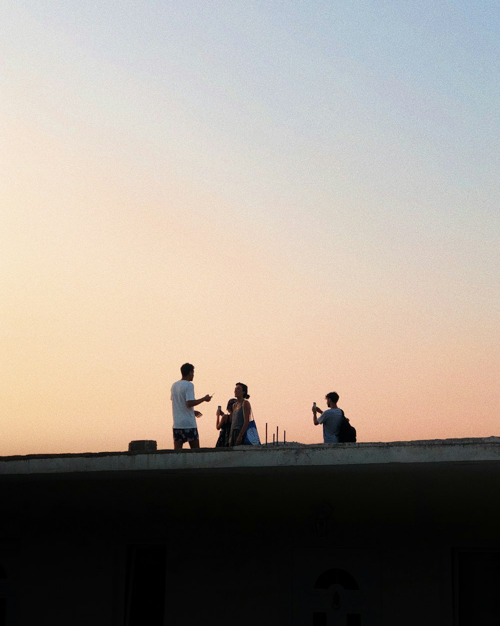 people standing on concrete wall during daytime