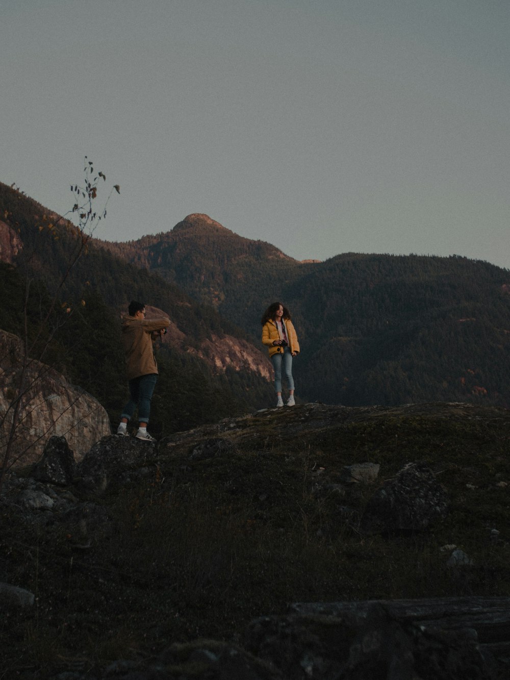 Uomo in camicia bianca in piedi sulla montagna rocciosa durante il giorno