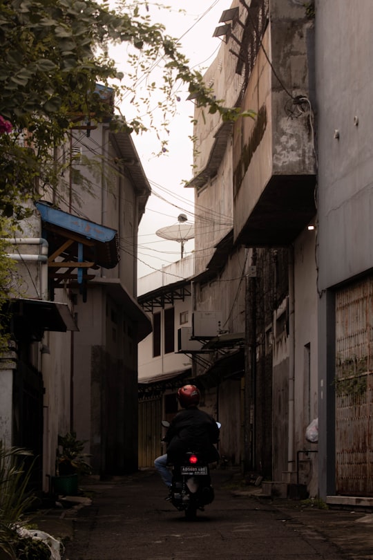 person in black jacket standing on sidewalk during daytime in Klaten Indonesia