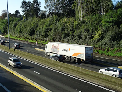 A fleet of trucks driving along a wide highway under a clear blue sky, symbolizing smooth logistics.
