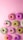 Close-up of colorful doughnuts arranged on a pink and purple themed table
