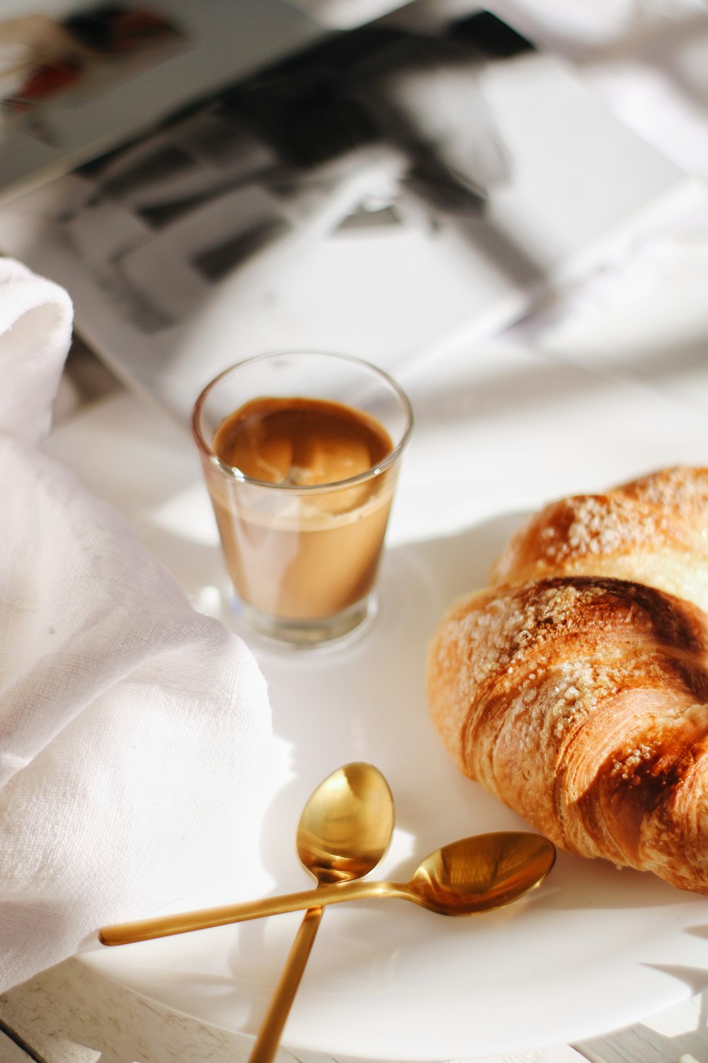 bread on white textile beside clear drinking glass