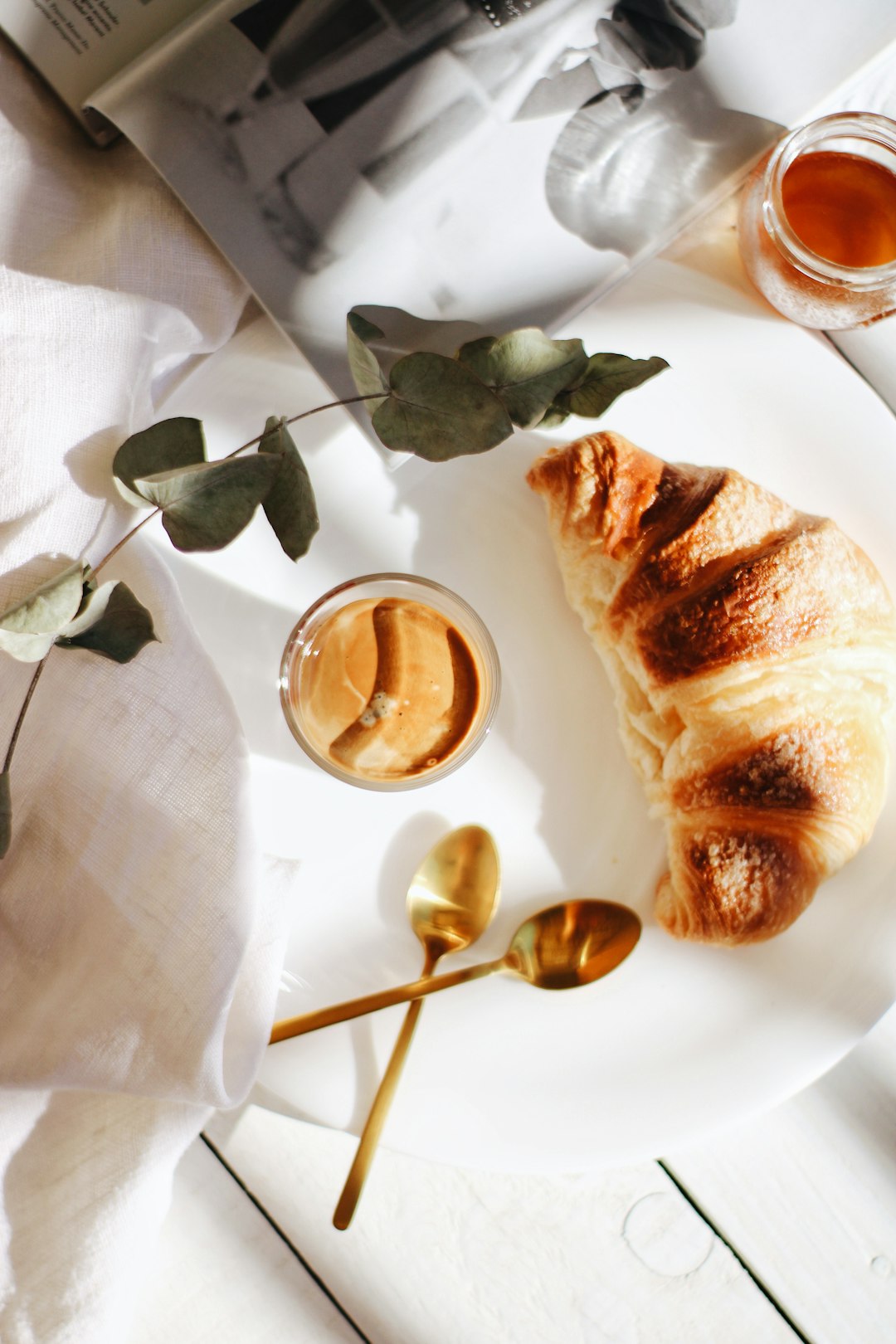 bread on white paper beside clear drinking glass