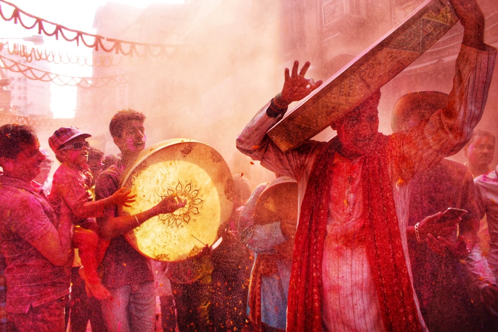 man in red dress holding round hand fan