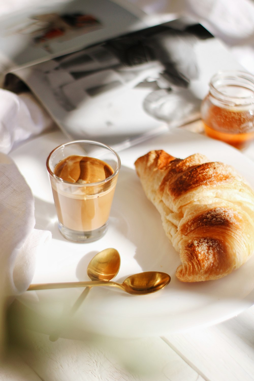 bread on white tissue paper beside stainless steel spoon