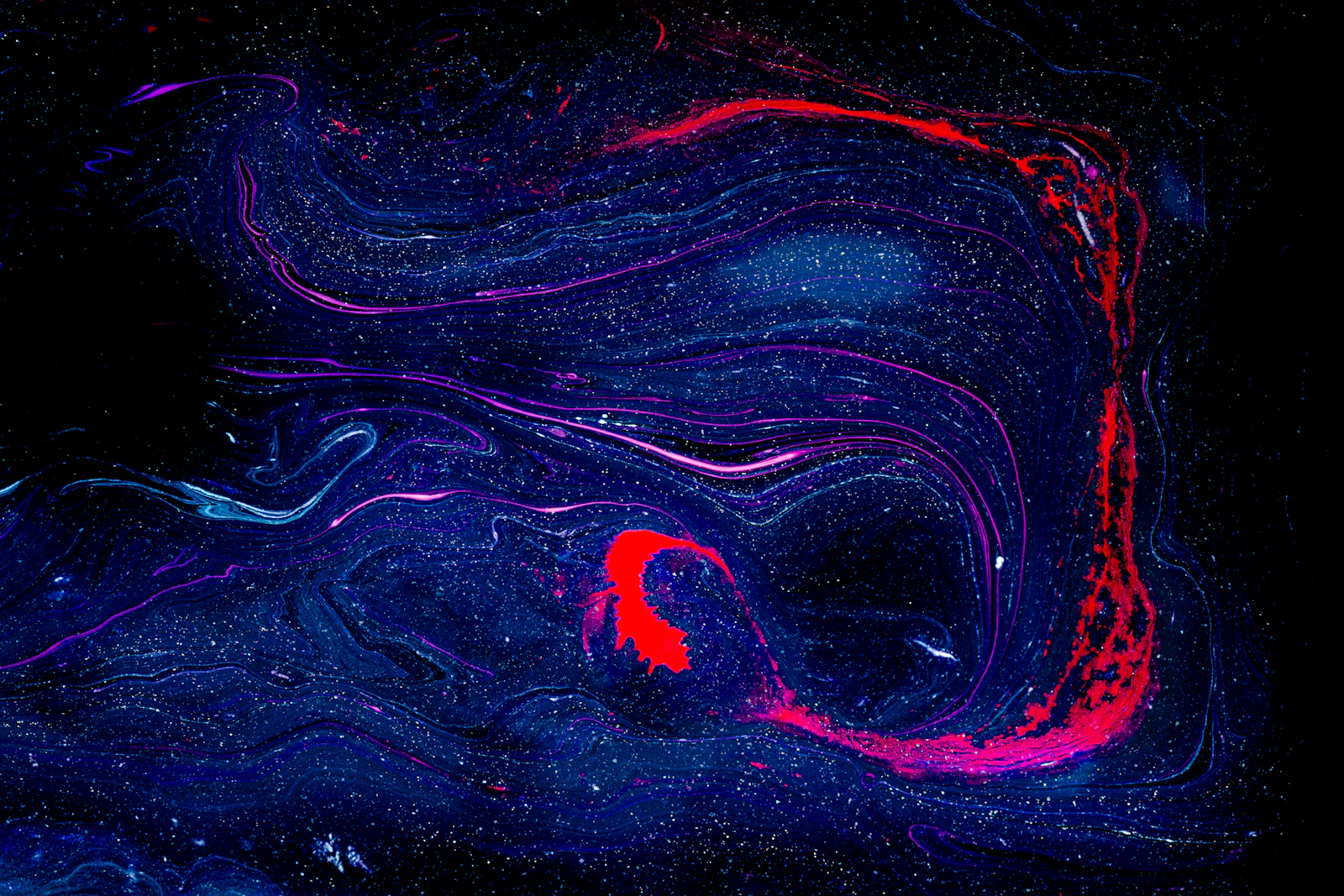 Swirling dark blue and purple cosmic nebula with subtle light fragments emerging