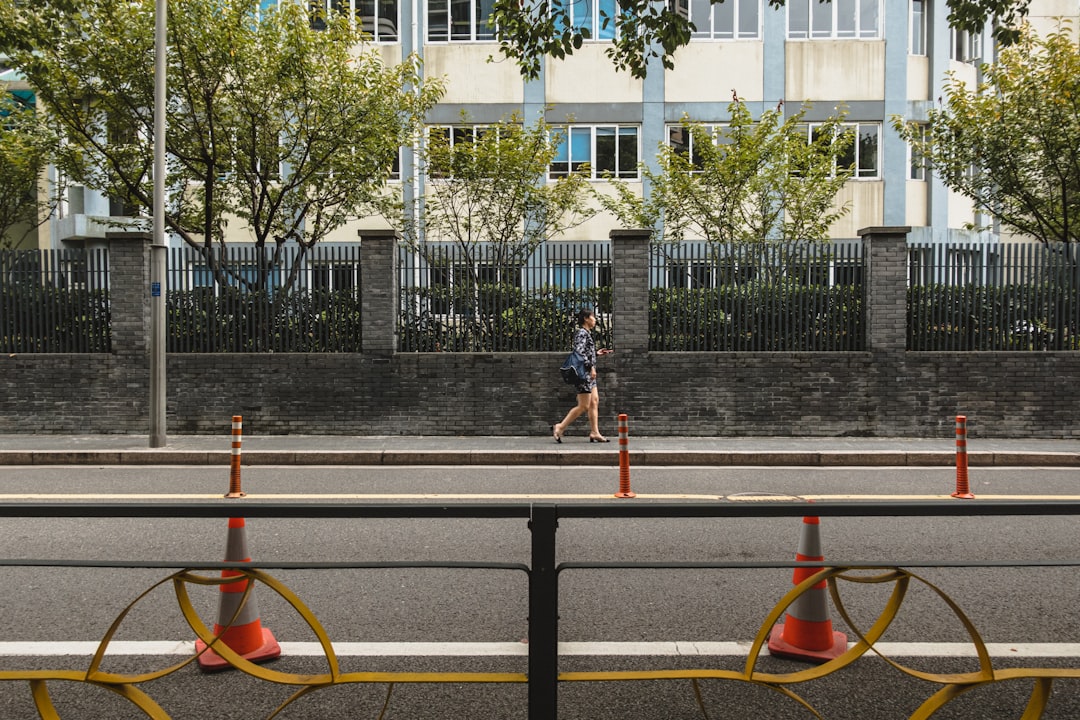 woman in white shirt and black shorts standing on gray concrete road during daytime