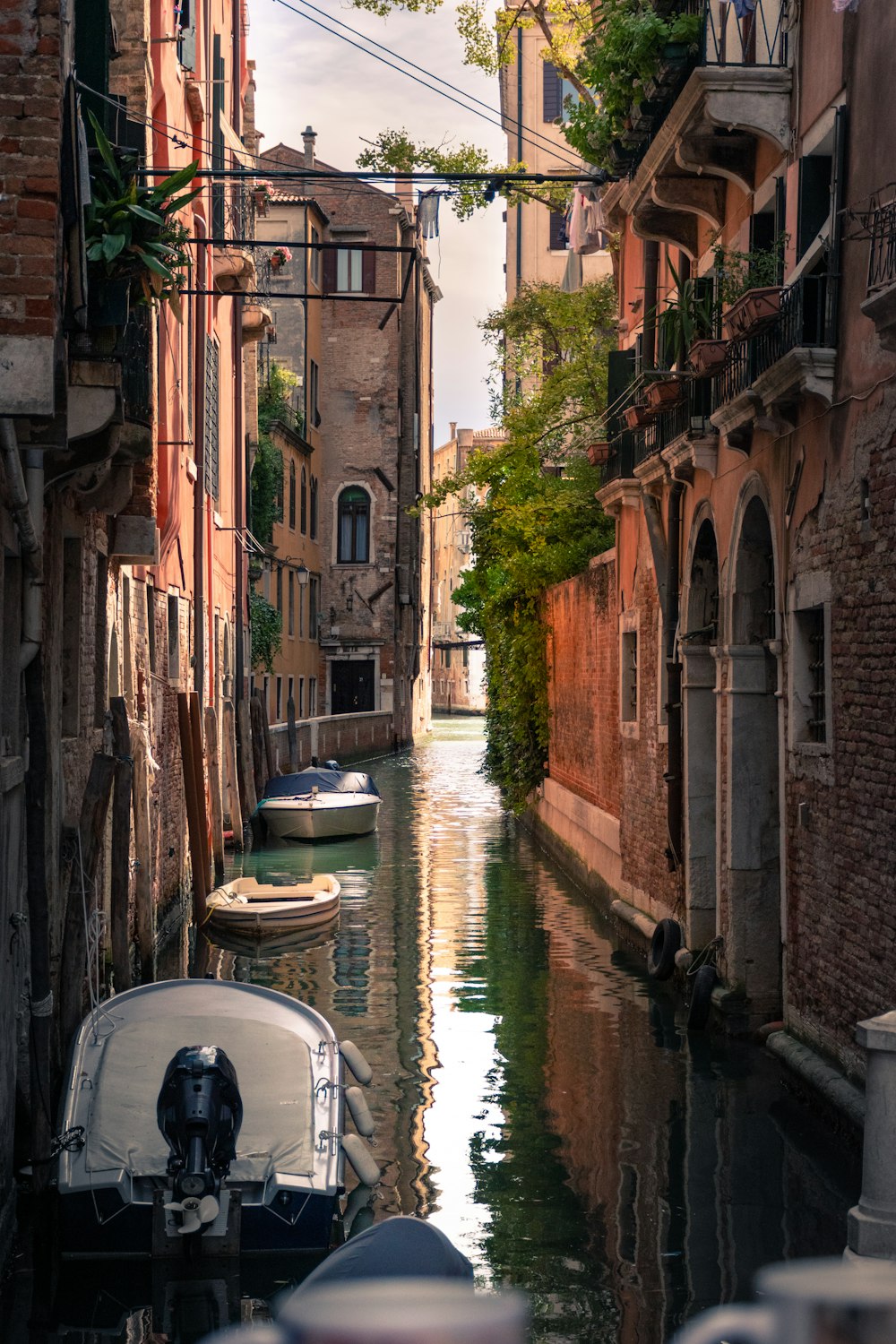 white boat on river between brown concrete buildings during daytime