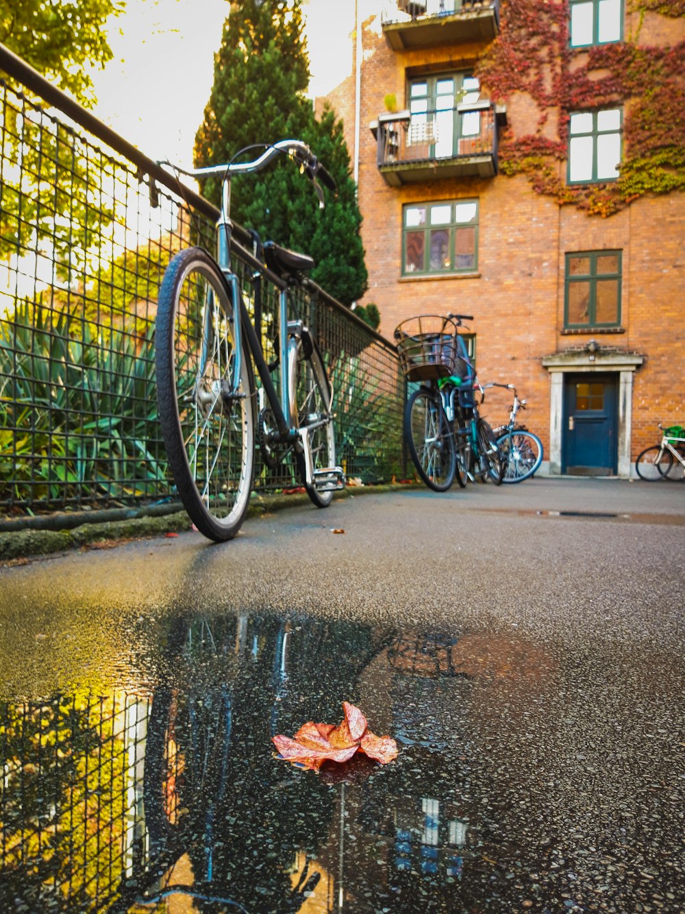 black commuter bike parked beside brown concrete building during daytime