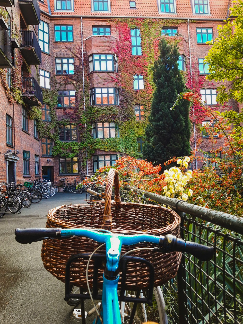 blue city bike parked beside brown concrete building during daytime