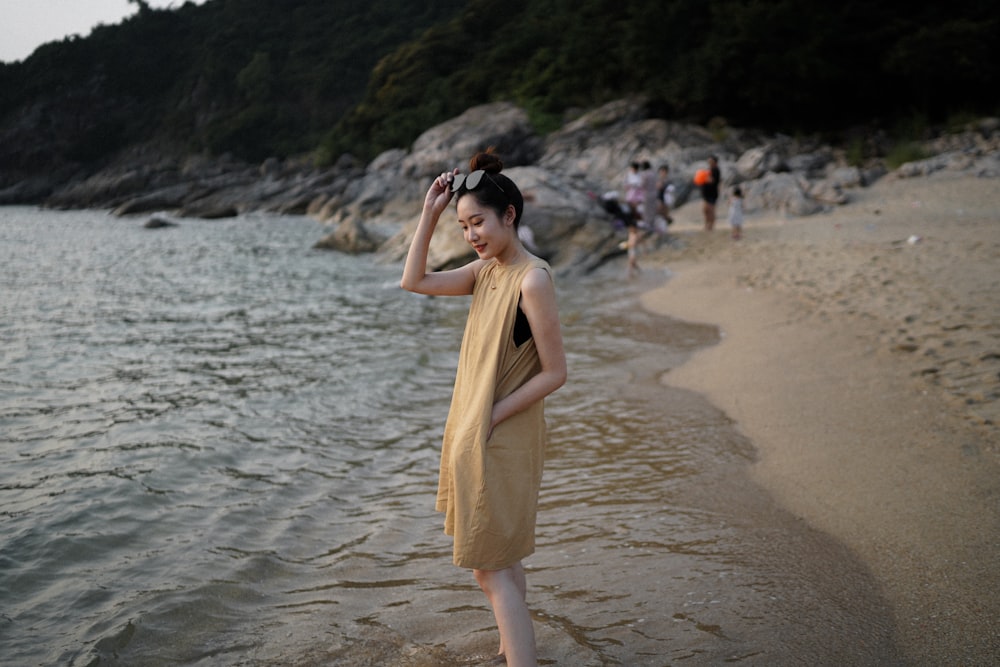 Frau in gelbem ärmellosem Kleid tagsüber am Strand