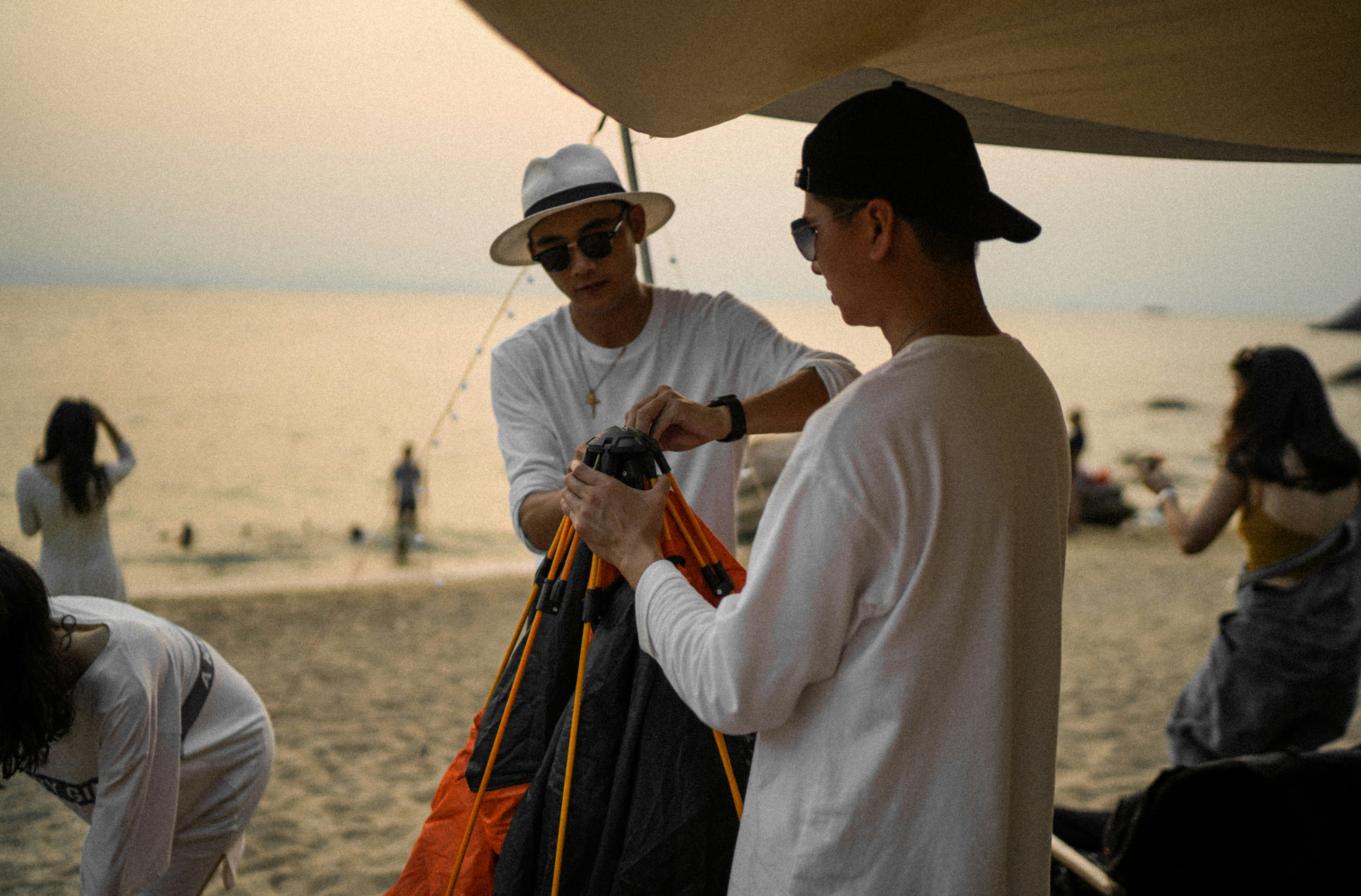 黒いデジタル一眼レフカメラを持っている白い長袖シャツと黒いズボンの男