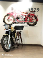 A classic Jawa motorcycle resting beside a vibrant street mural celebrating Indian motorcycling culture.