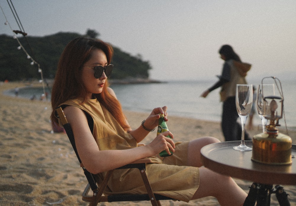 woman in yellow tank top sitting on brown wooden chair during daytime