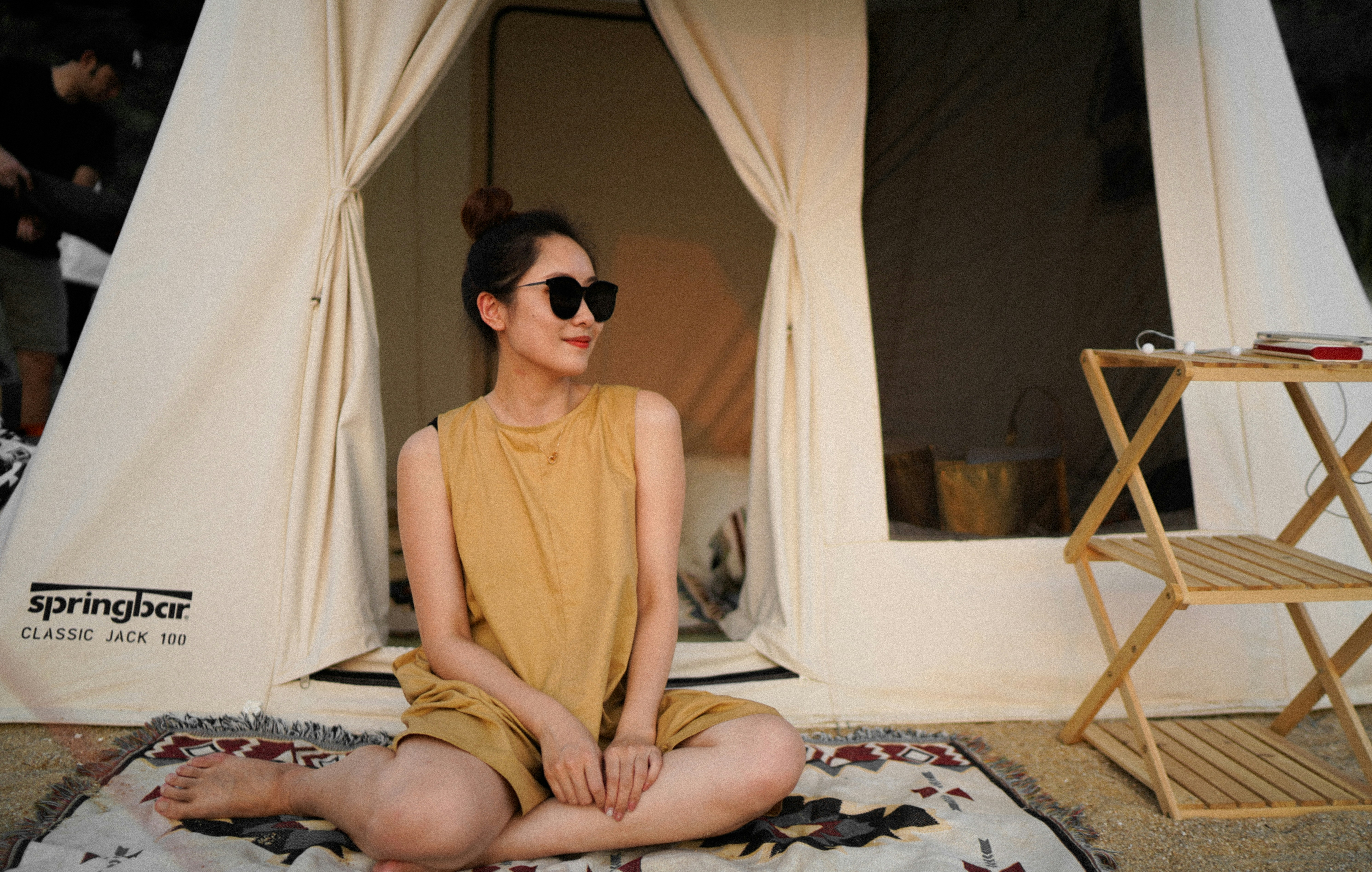 ベッドに座っている茶色のタンクトップを着た女性