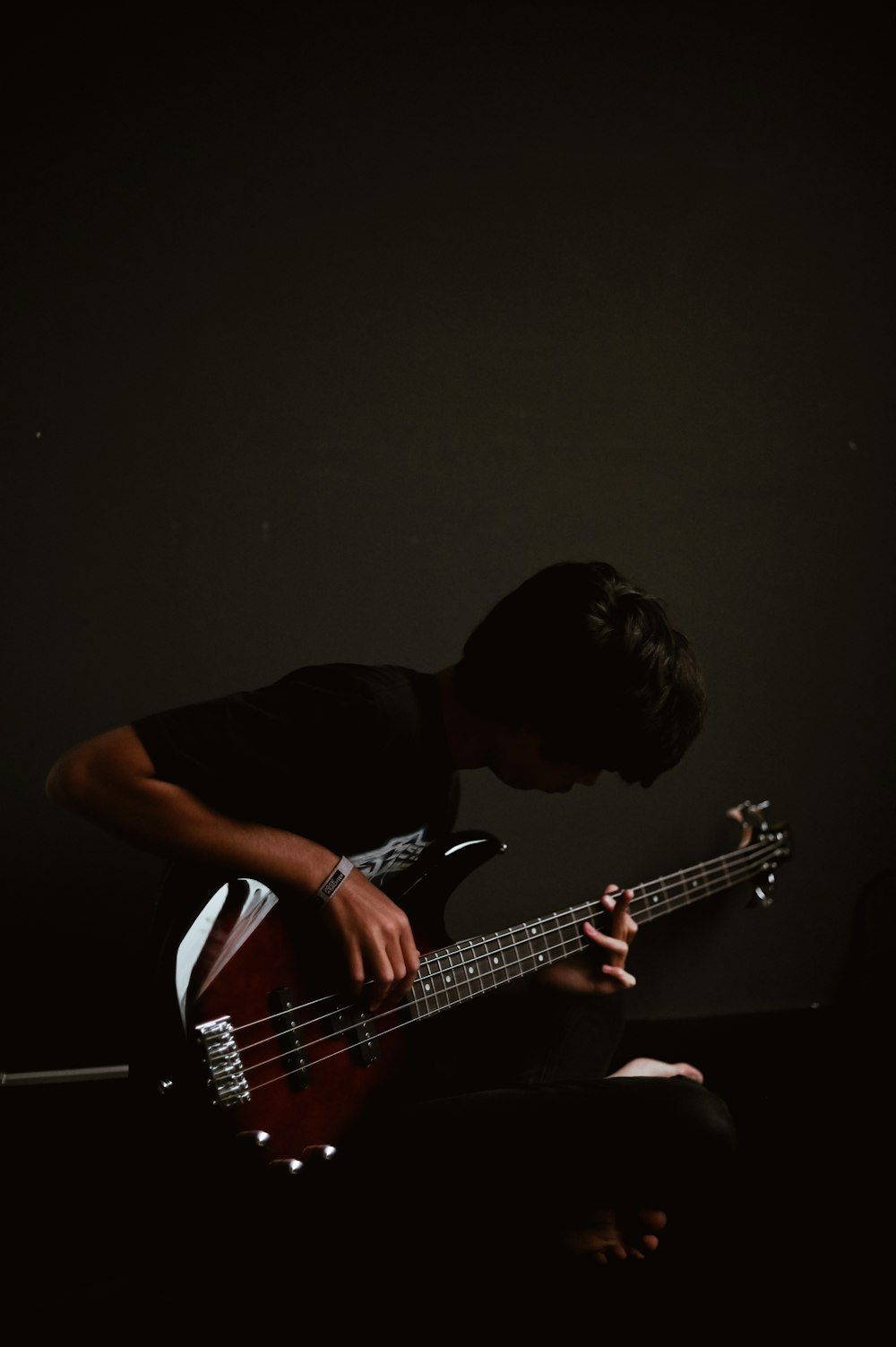 man in black t-shirt playing guitar