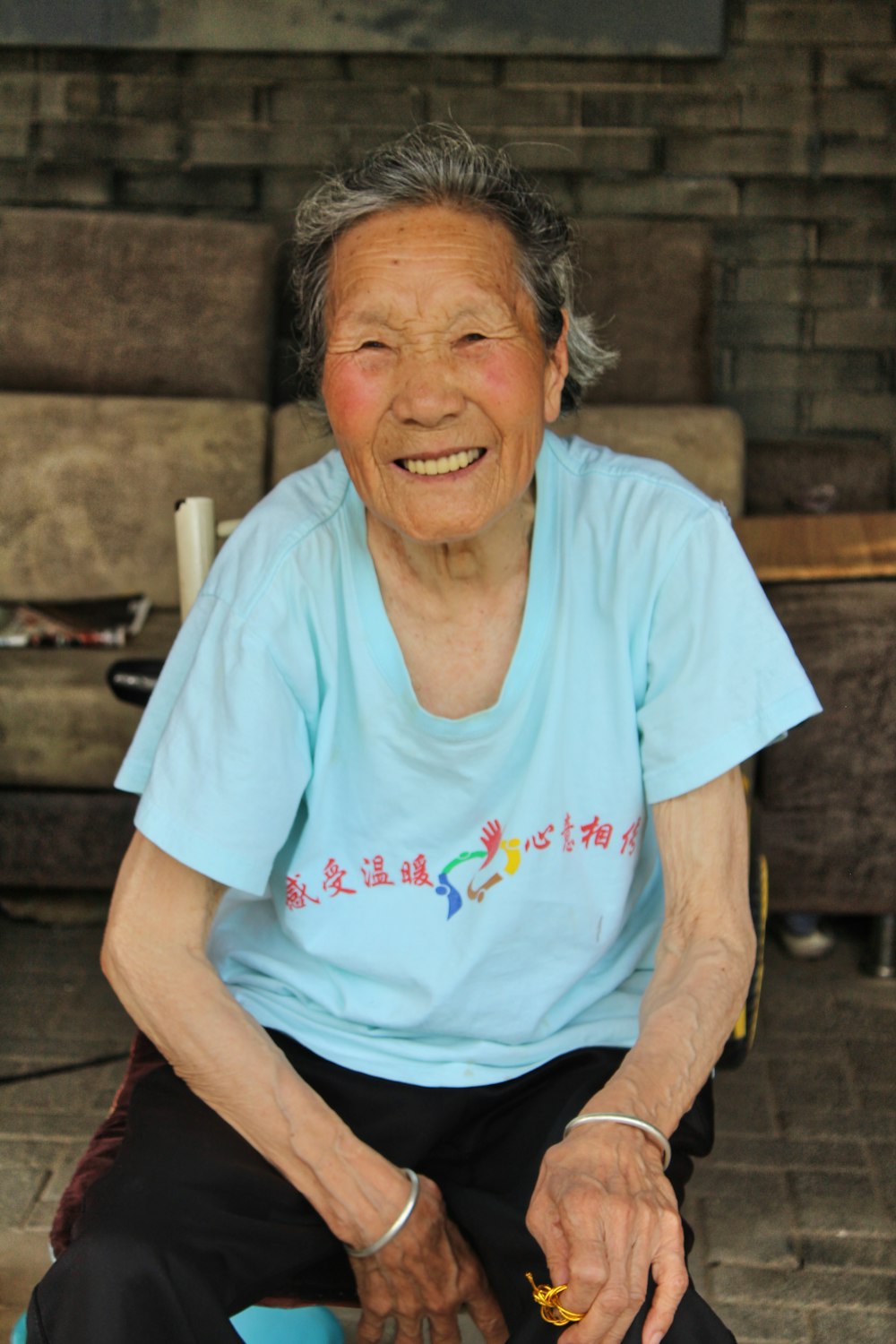 woman in blue crew neck t-shirt sitting on brown wooden bench