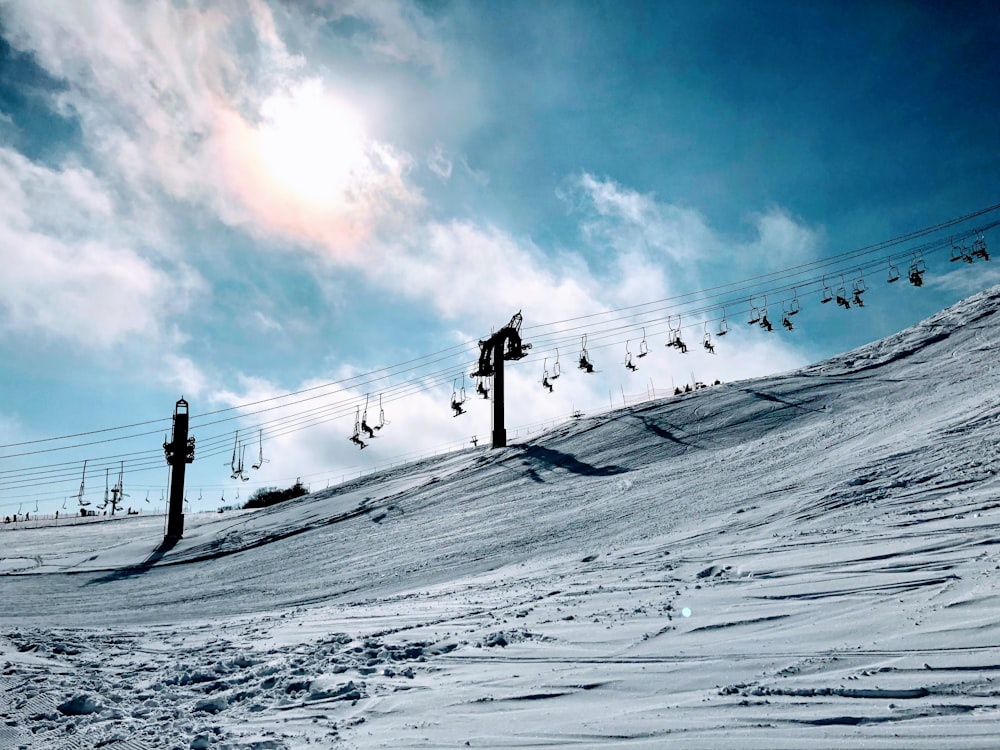 people walking on snow covered field under blue and white sunny cloudy sky during daytime