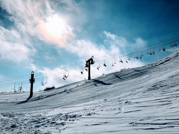 people walking on snow covered field under blue and white sunny cloudy sky during daytimeby Stanley Cheung