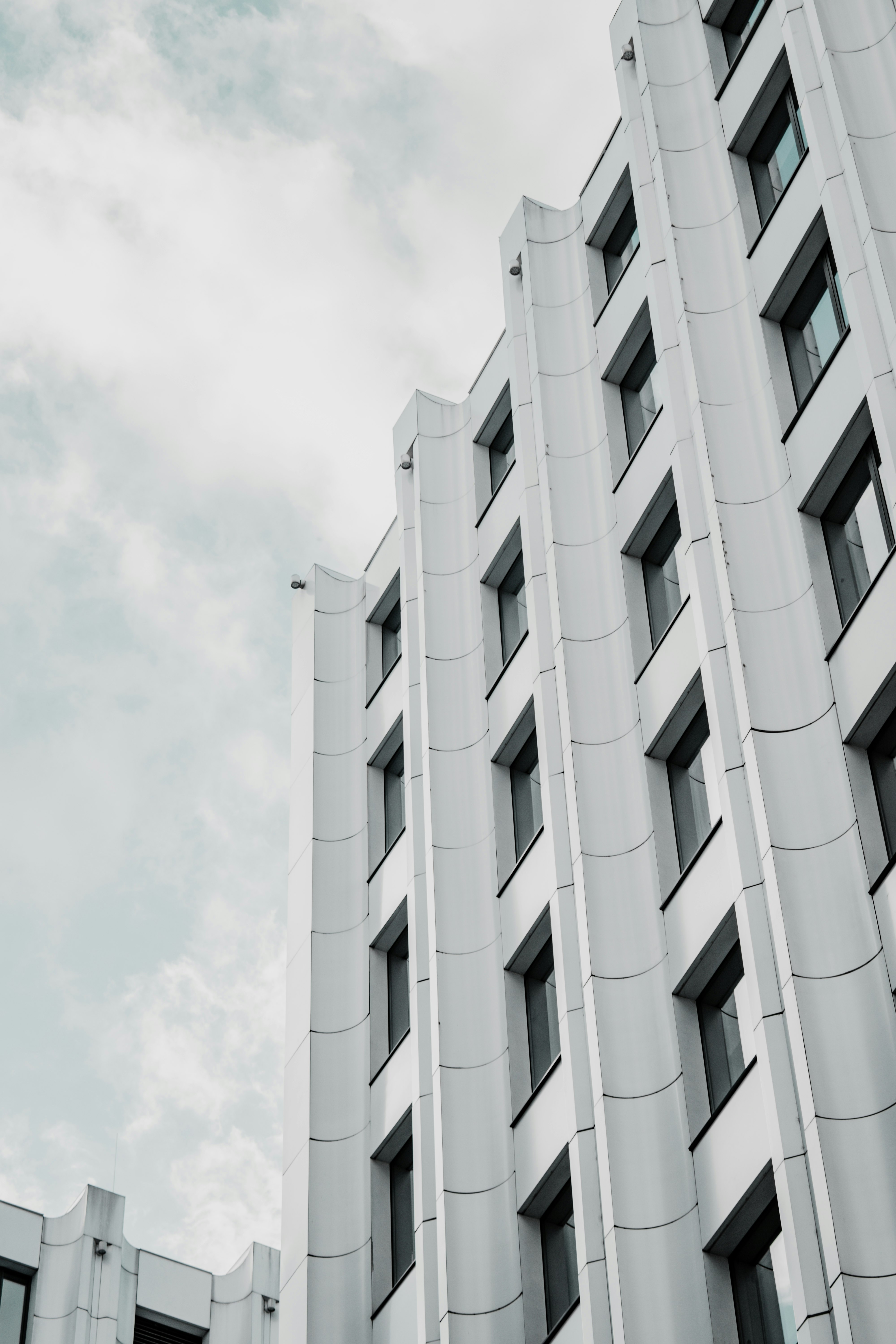 white concrete building under white clouds during daytime