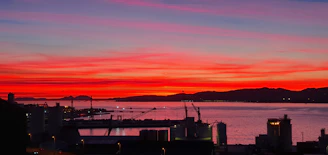 A vibrant sunset over Trondheim’s harbor, with reflections dancing on the water.