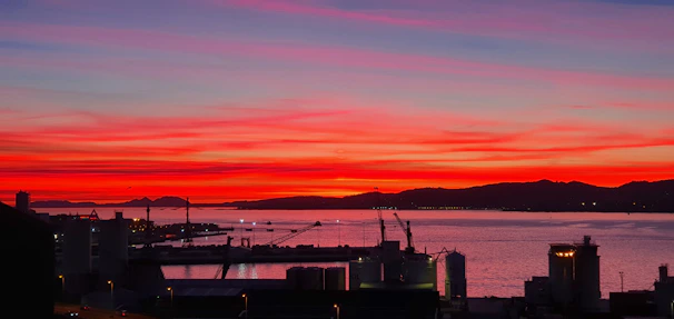 A vibrant sunset over Trondheim’s harbor, with reflections dancing on the water.