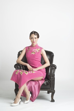 A romantic pink dress displayed on a vintage chair.