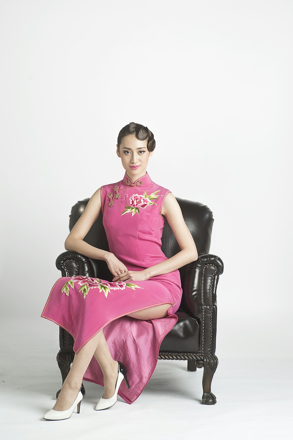 woman in purple sleeveless dress sitting on black leather armchair