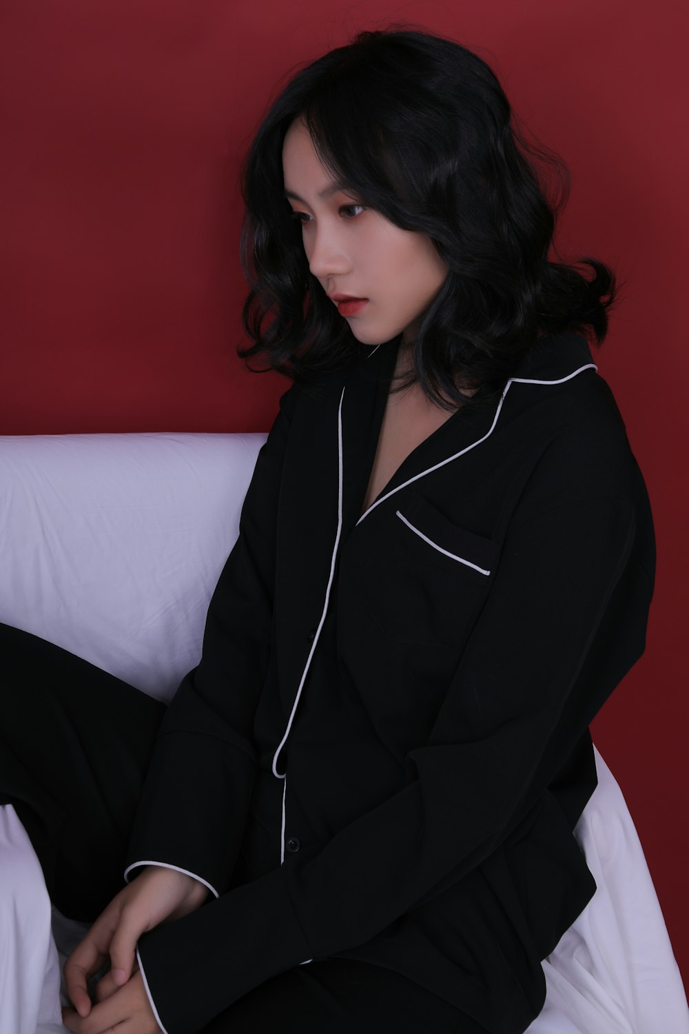 woman in black blazer sitting on white sofa