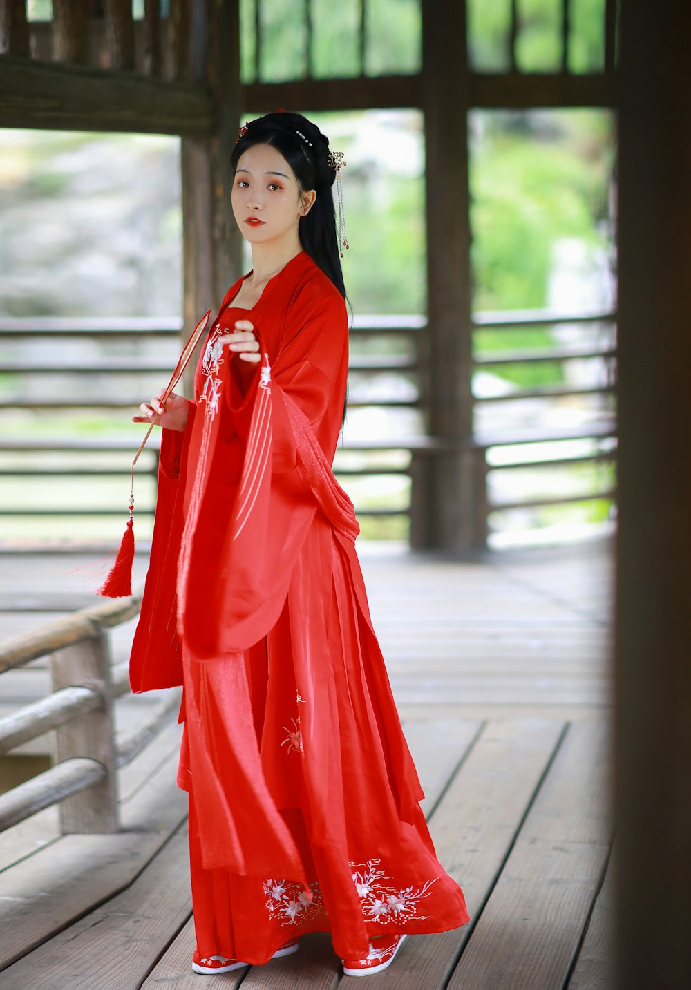 woman in red long sleeve dress standing on gray concrete floor during daytime