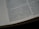 A close-up view of an open book showing columns of text with visible paragraphs and a dotted line margin on the left. The text is sharp and printed on a slightly off-white, matte paper, suggesting it could be a page from a religious or reference book.