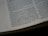 A close-up view of an open book showing columns of text with visible paragraphs and a dotted line margin on the left. The text is sharp and printed on a slightly off-white, matte paper, suggesting it could be a page from a religious or reference book.