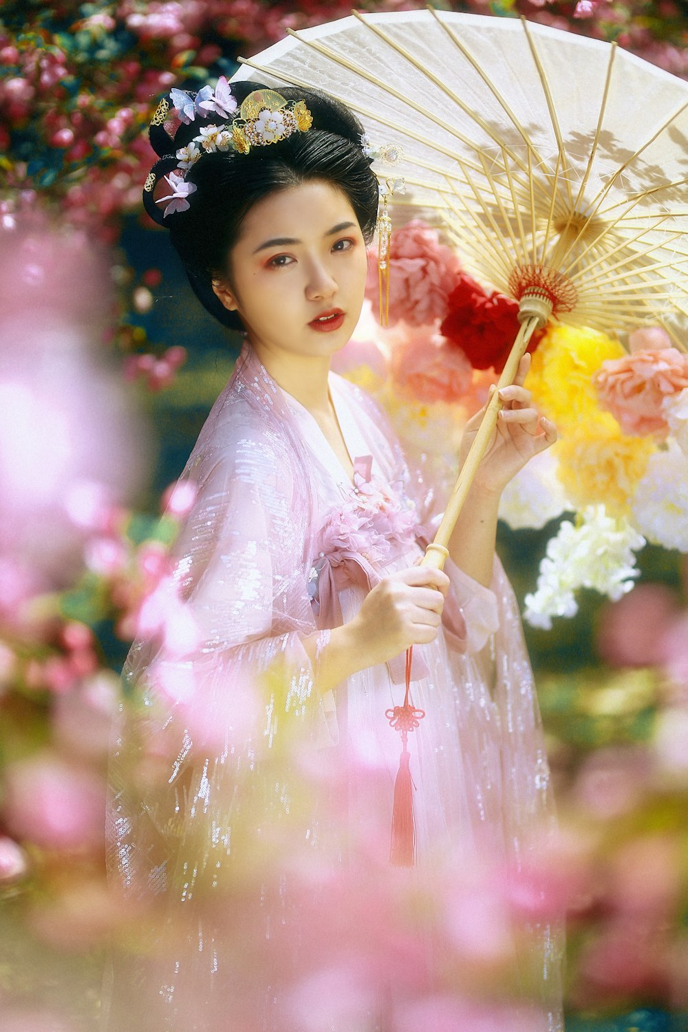 Mujer en kimono floral rosa y blanco sosteniendo ramo de flores amarillas y blancas