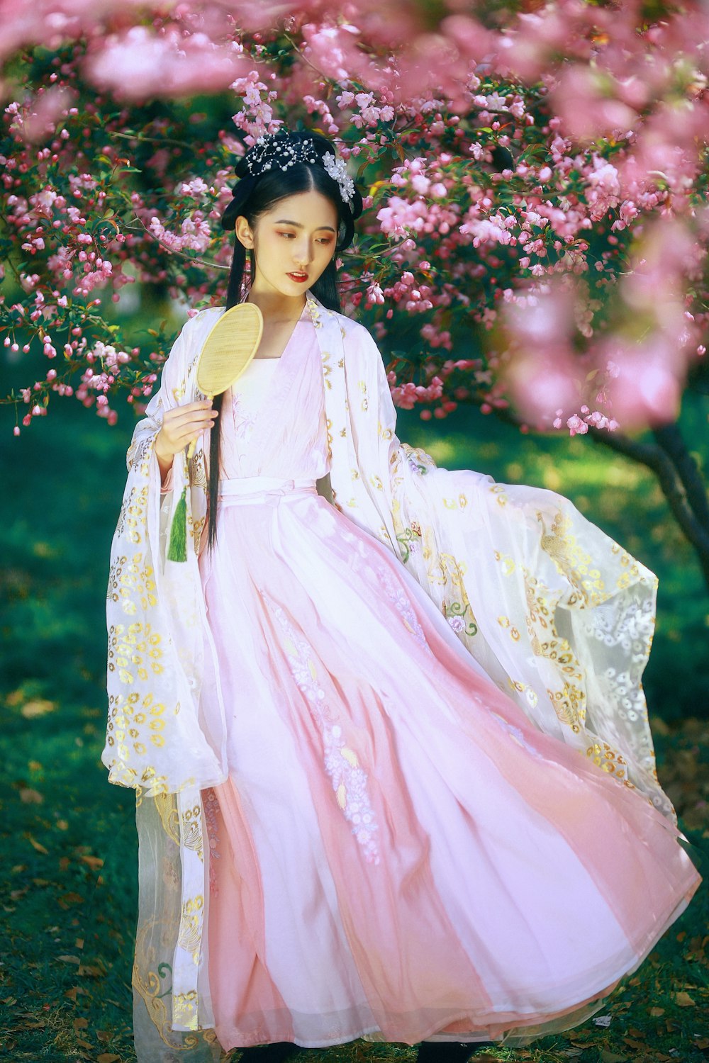 woman in white and pink dress standing beside pink flowers