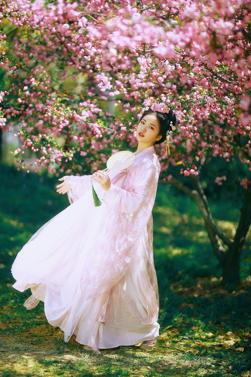 woman in white dress standing near pink flowers
