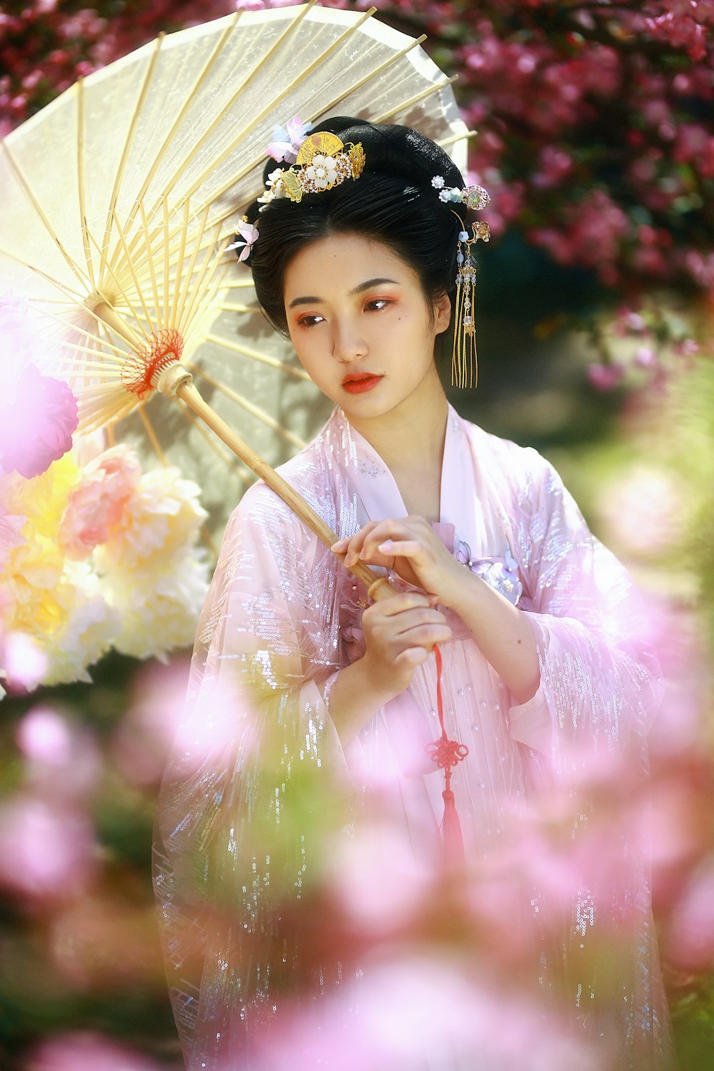 woman in white and pink floral kimono holding umbrella