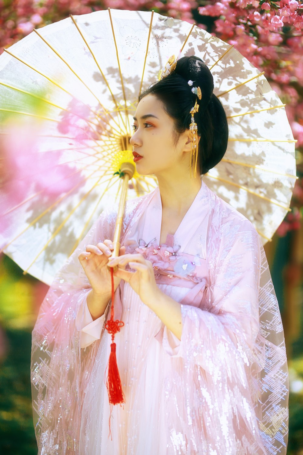 woman in white and pink floral kimono holding umbrella