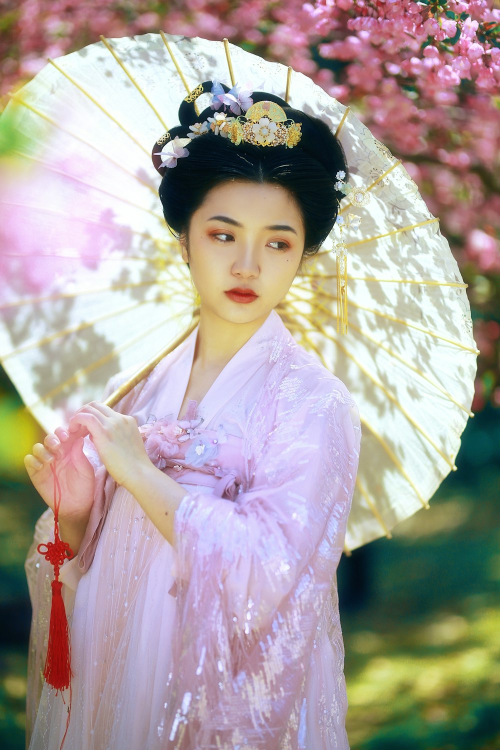 Mujer en kimono rosa sosteniendo paraguas