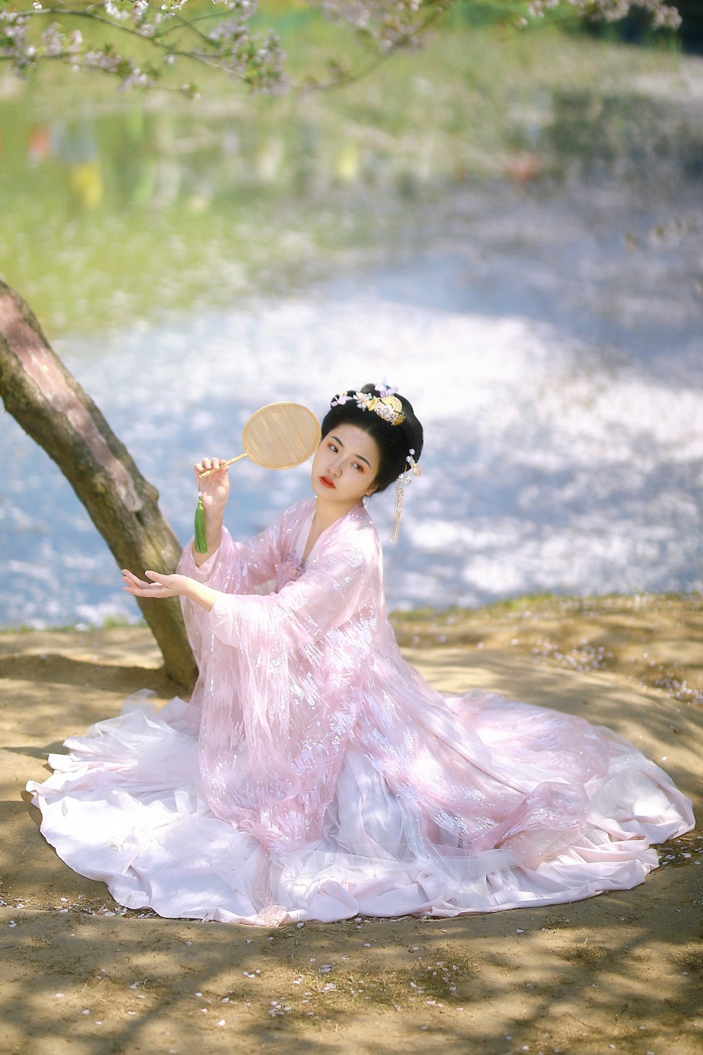girl in pink dress sitting on tree branch