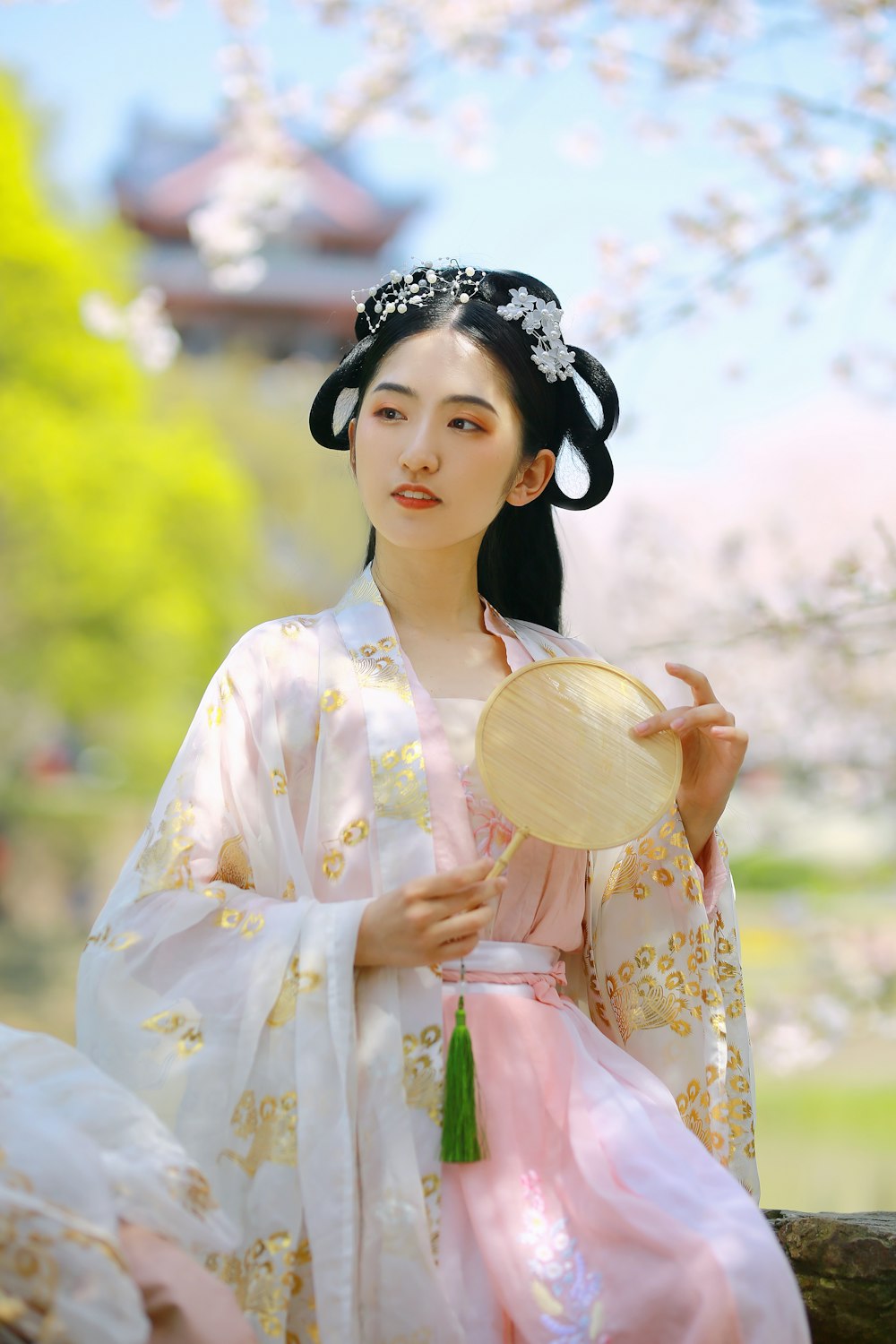 woman in white and yellow floral dress holding brown hat