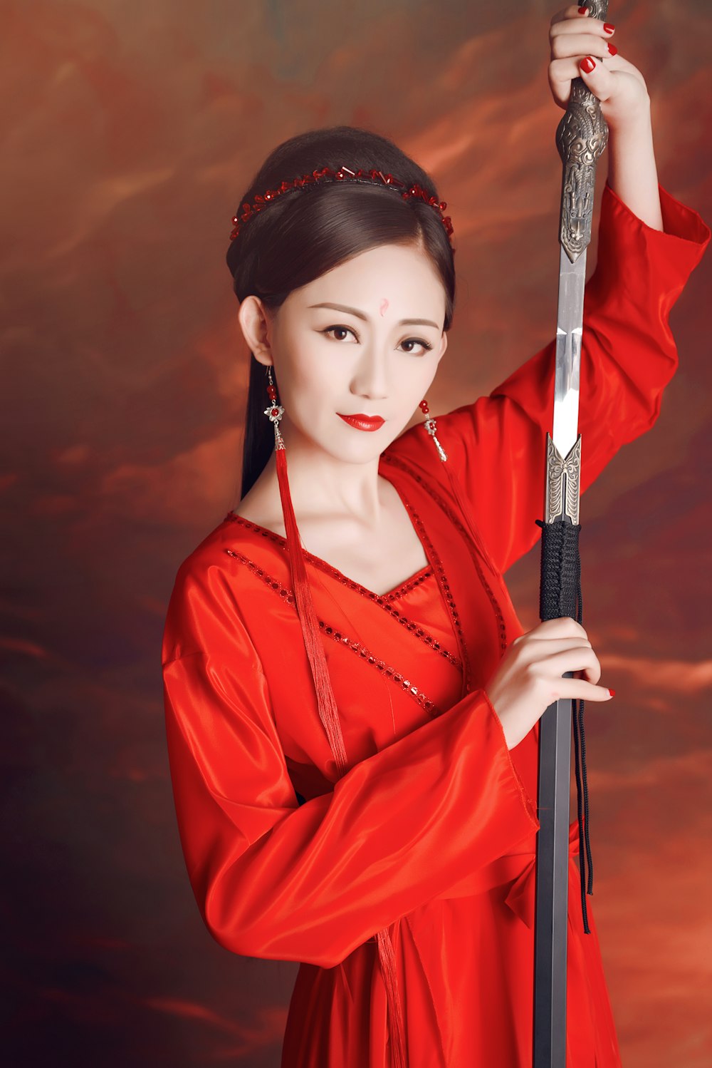 woman in red kimono holding black and gray sword