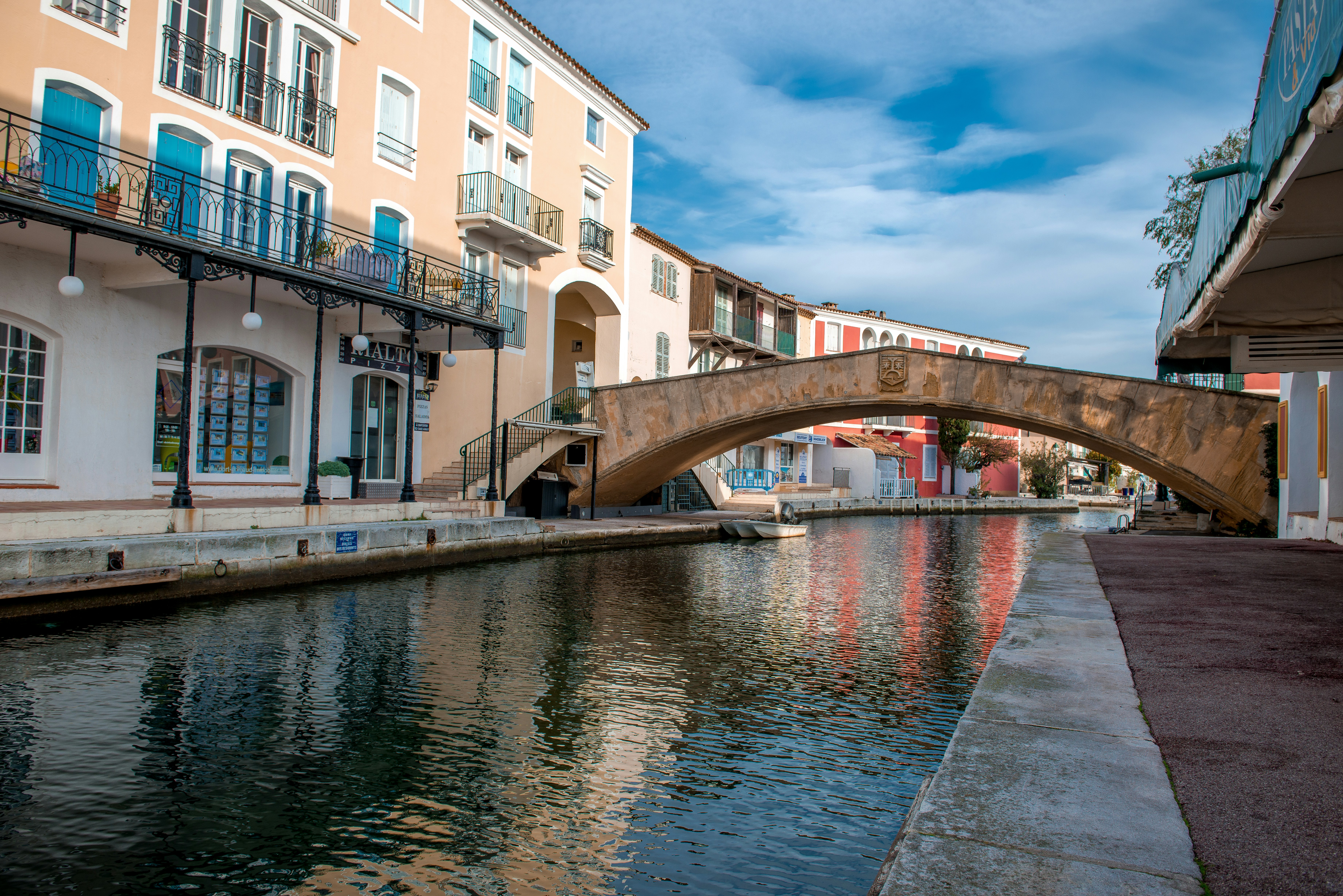white and brown concrete building near river under blue sky during daytime